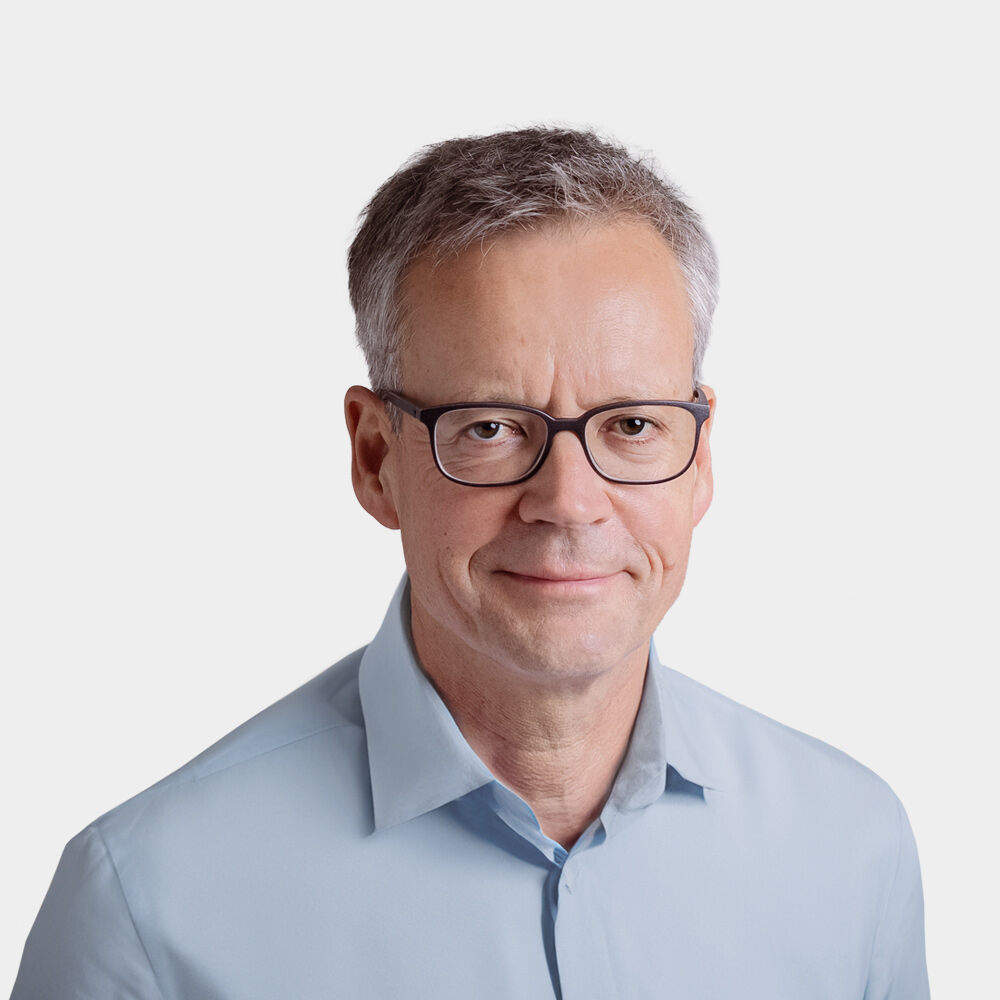 Hans Georg Scheibe, Managing Partner Portraetfoto von Hans Georg Scheibe vor grauem Hintergrund