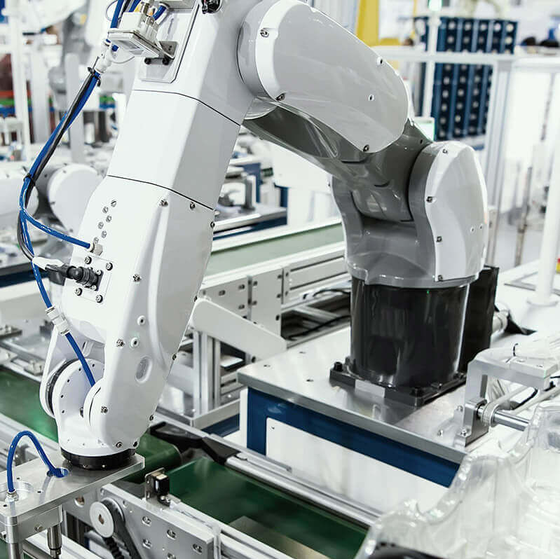 Eine Fabrikhalle in der der ein Roboter die Arbeit verrichtet