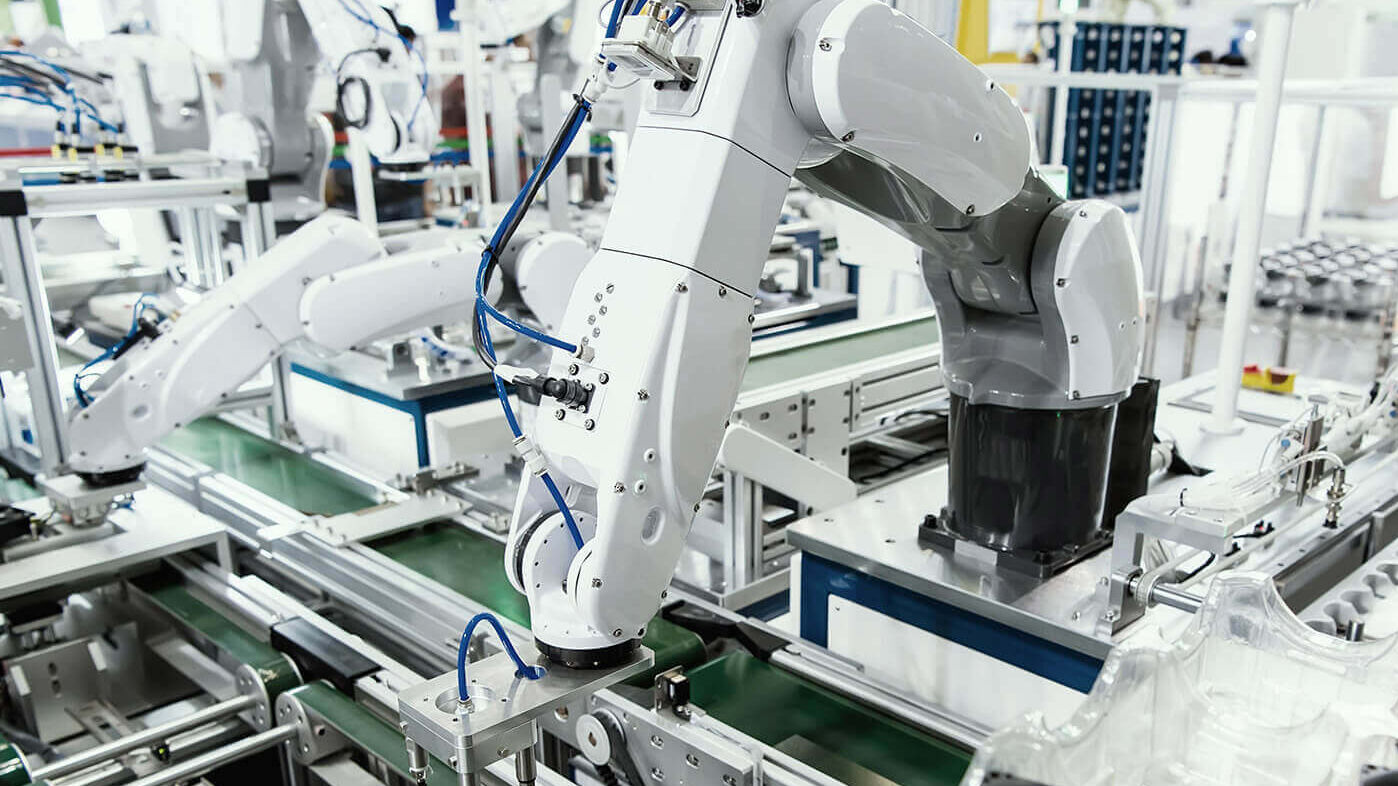 Eine Fabrikhalle in der der ein Roboter die Arbeit verrichtet