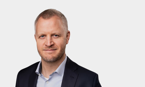 Portraitfoto von Sebastian Diers vor grauem Hintergrund