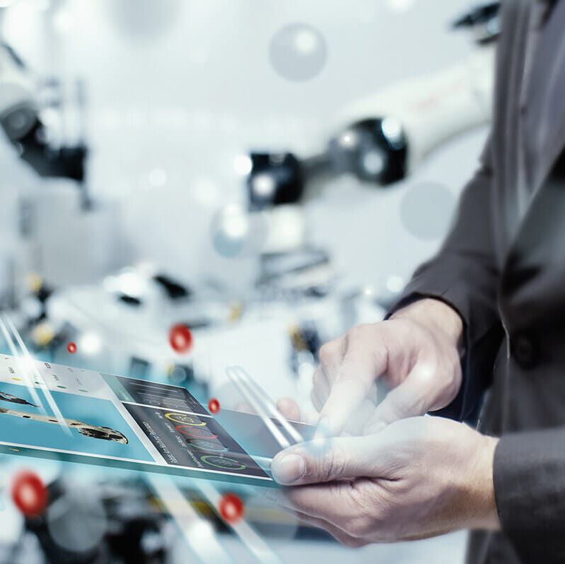 Mann mit futuristischem Tablet in einer Fabrik mit End-to-End Digitalisierung