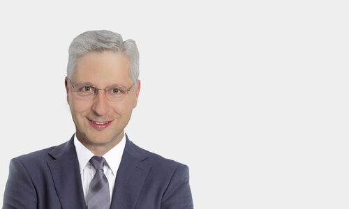 Portraitfoto von Dr. Pete Acel vor grauem Hintergrund