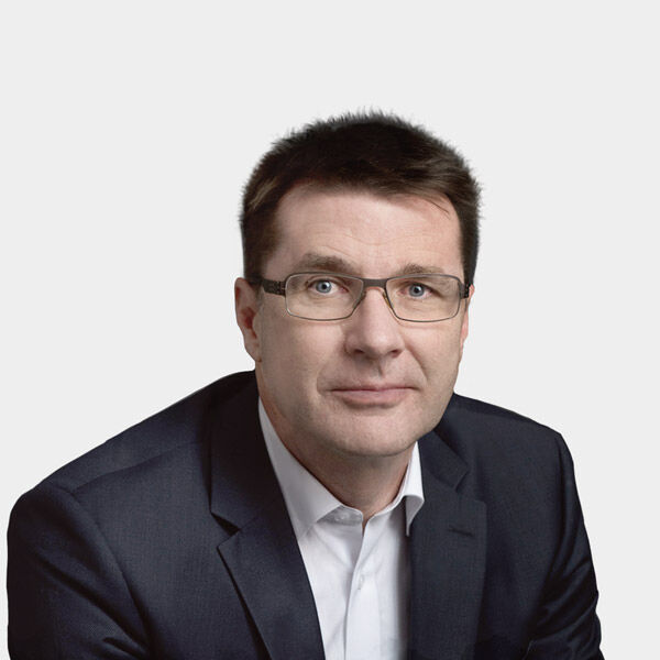 Portraitfoto von Elmar Hubner vor grauem Hintergrund