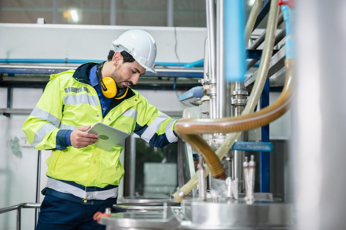 Männlicher Mitarbeiter in Schutzkleidung im nachhaltigen Chemieunternehmen