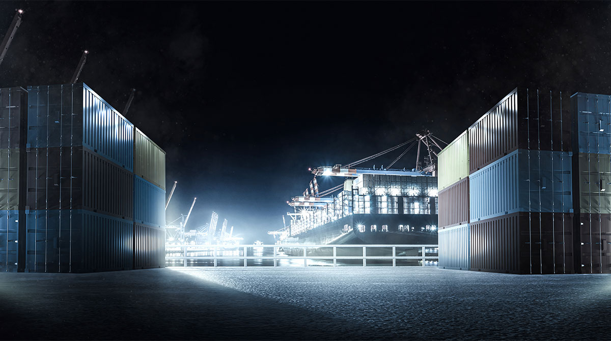 A container yard of a port at night which is illuminated.