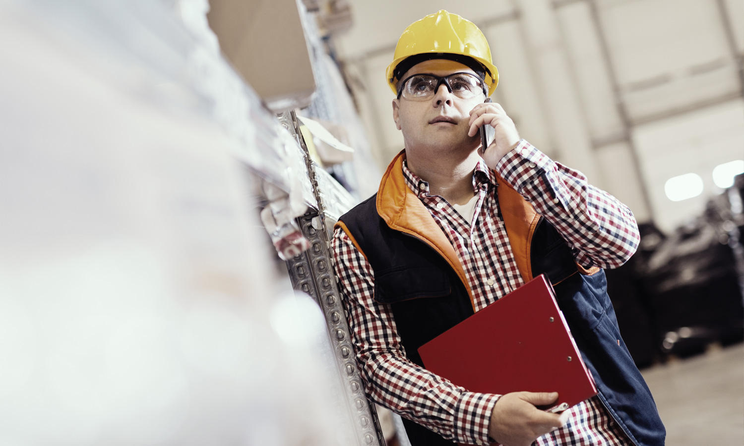 ROI Supply Chain Controlling Mann am Telefon in einer Lagerhalle