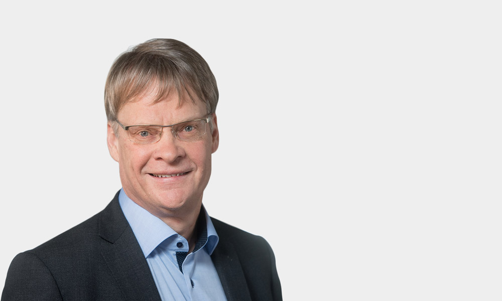 Werner Bick, Senior Partner Portraetfoto von Werner Bick vor grauem Hintergrund