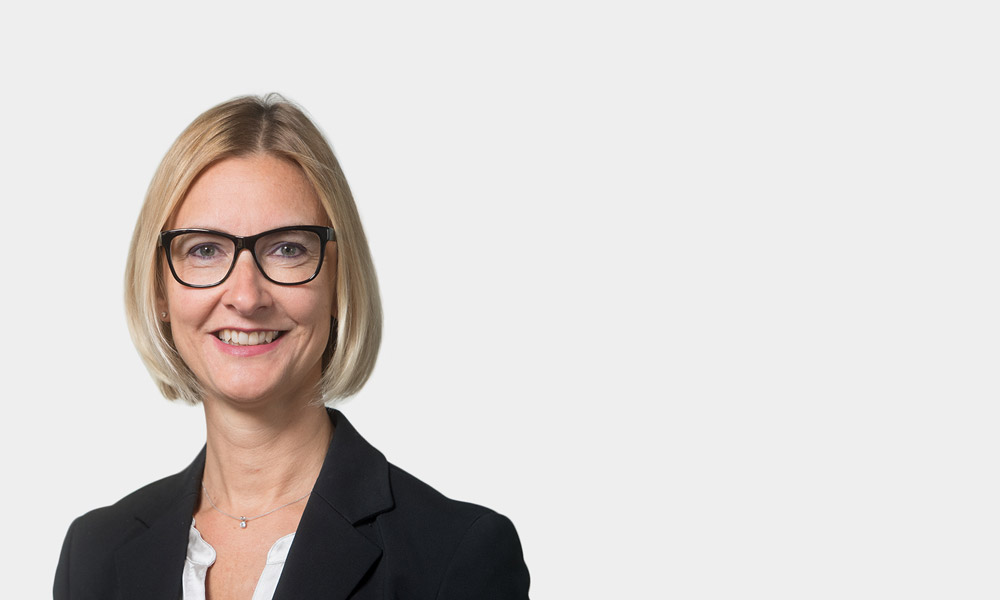 Susanne Drexl-Wittbecker, Partner Portraetfoto von Susanne Drexl-Wittbecker vor grauem Hintergrund