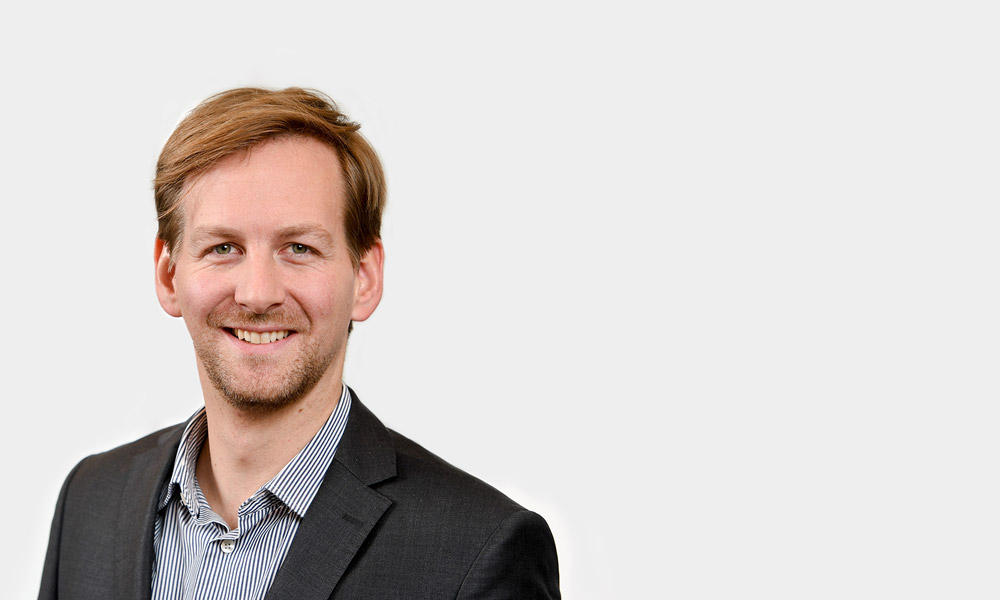 Christian Kraus, Consultant Portraetfoto von Christian Kraus vor grauem Hintergrund