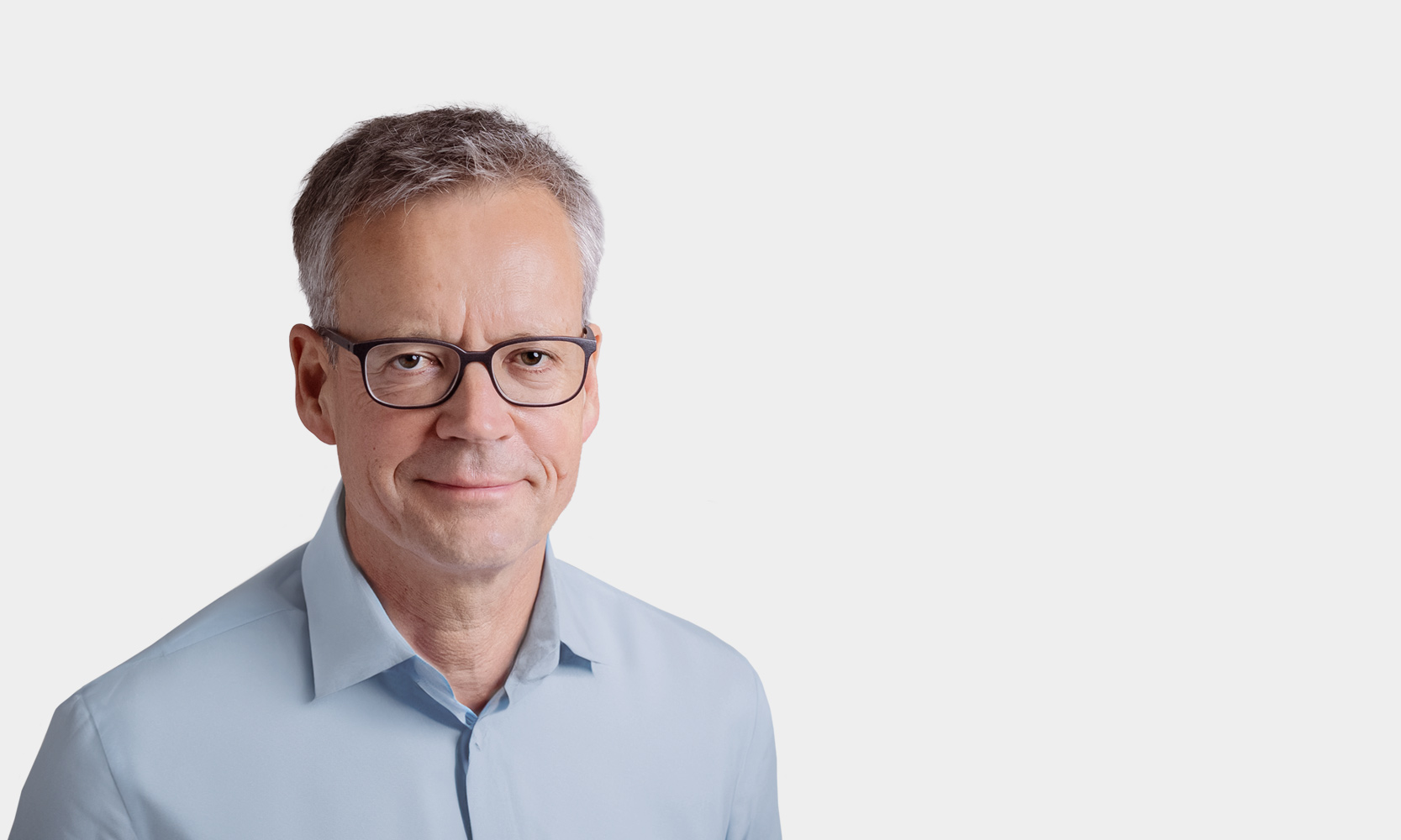 Hans Georg Scheibe, Managing Partner Portraetfoto von Hans Georg Scheibe vor grauem Hintergrund